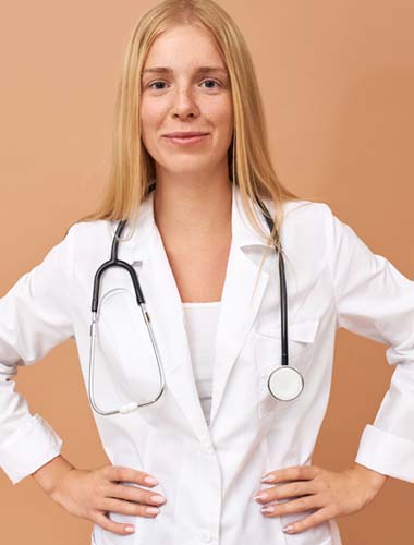 женщина врач с руками на поясе смотрит в камеру